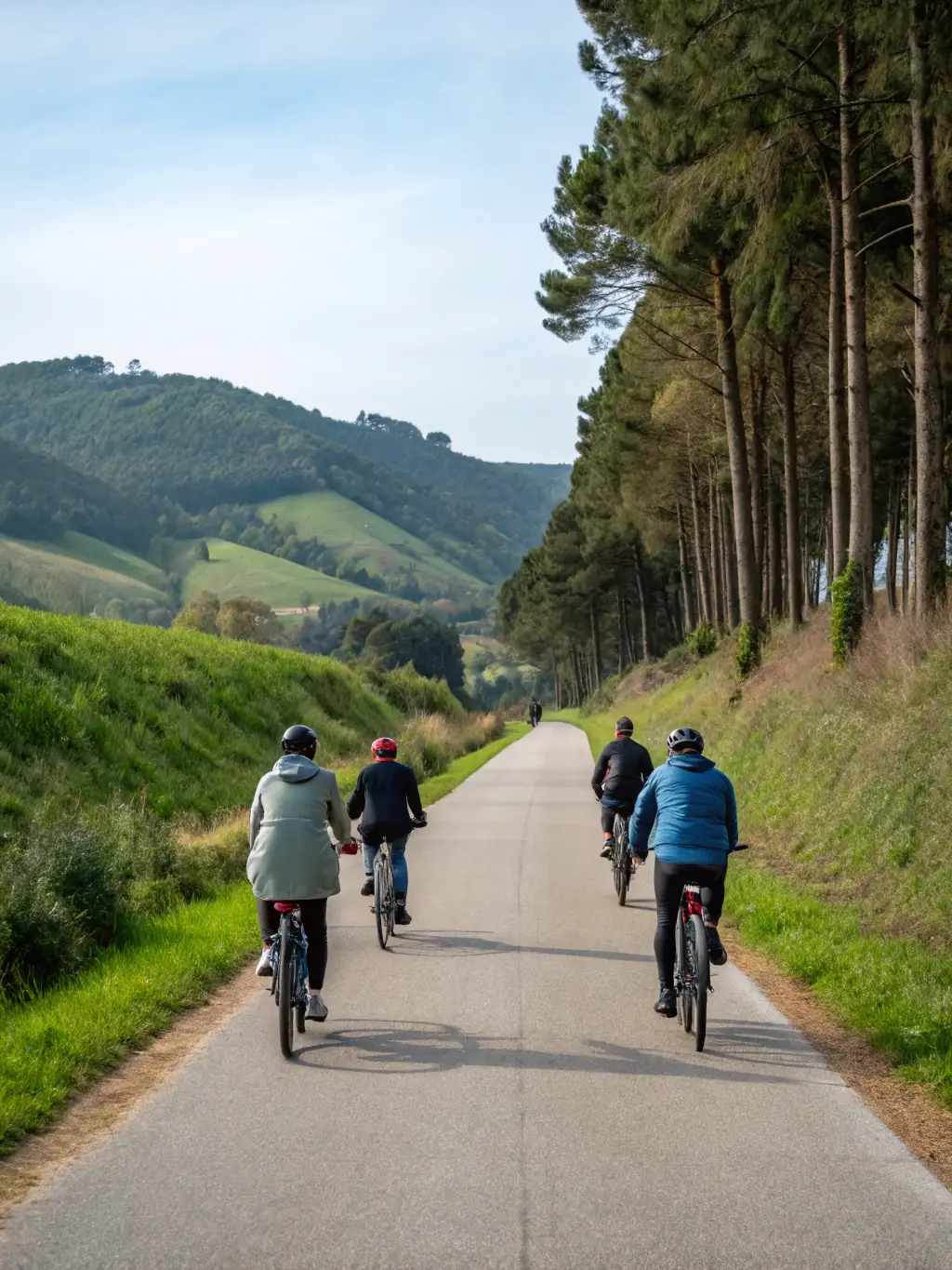A group of cyclists participating in a training session on a scenic rural road, with coaches providing guidance. The image is used to showcase the cycling training programs offered by Société La Pédale Sanfloraine.