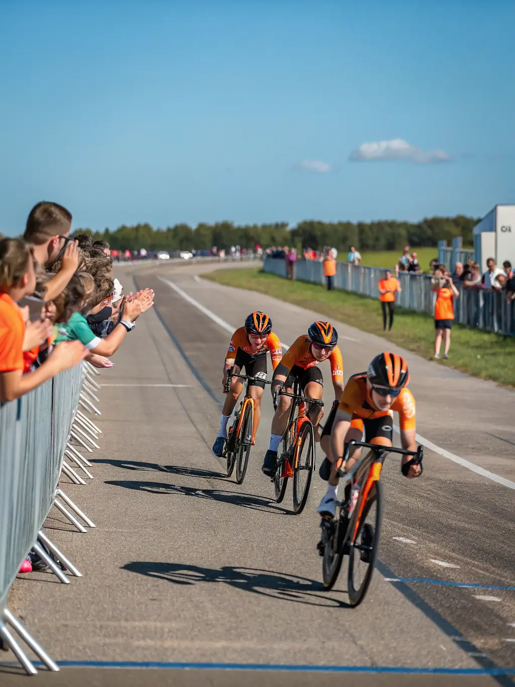 Cyclists competing in a local cycling competition, showcasing the intensity and excitement of the race, with spectators cheering on the participants. The event is branded with La Pédale Sanfloraine logos.